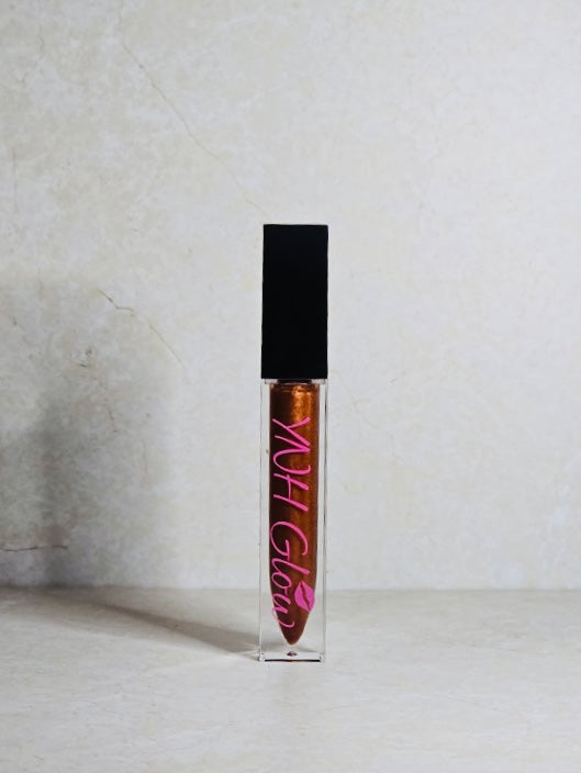 Golden hour Lip Gloss by YNH Glow - Bronze and copper-orange lip gloss in a sleek tube, offering a glossy finish with a warm, metallic shimmer.