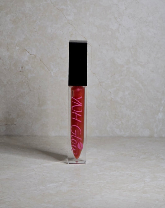 Rose Lip Gloss by YNH Glow - 
Pinkish-red lip gloss in a sleek tube, offering a soft, blend of pink and red hues with a glossy, smooth finish.